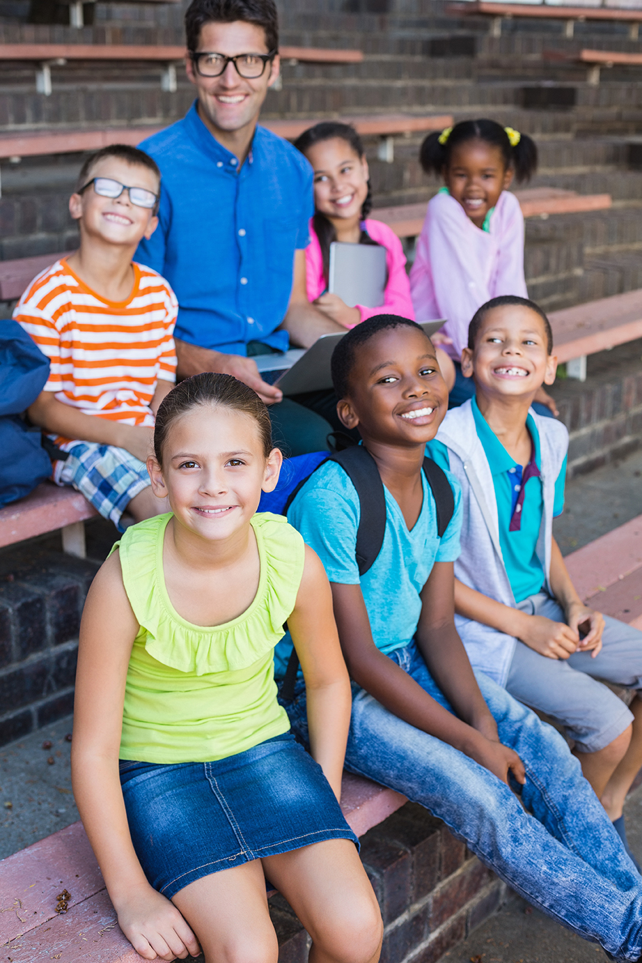 teacher and kids sitting on bench